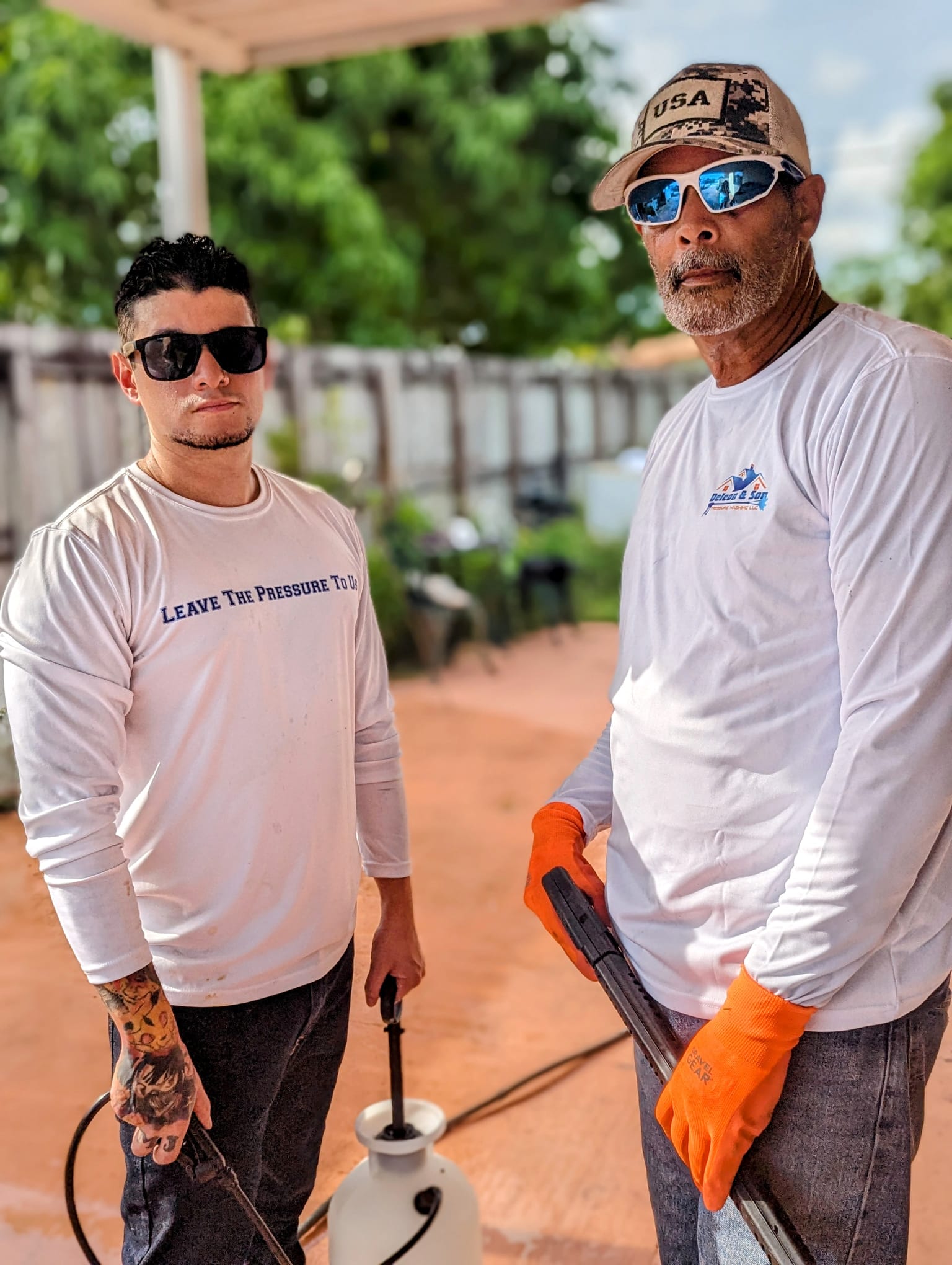 henry and carlos holding pressure washing equipment