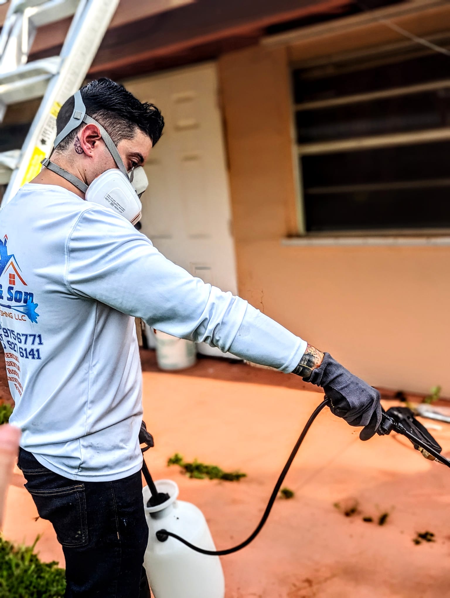 henry deleon using a chemical sprayer while wearing a face mask